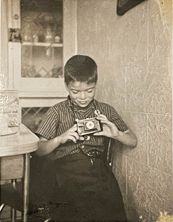 Lou D’Elia, age 5, with his new camera, 1956. (Photo taken by Lou’s dad with his Polaroid Land Camera Model one hundred.)